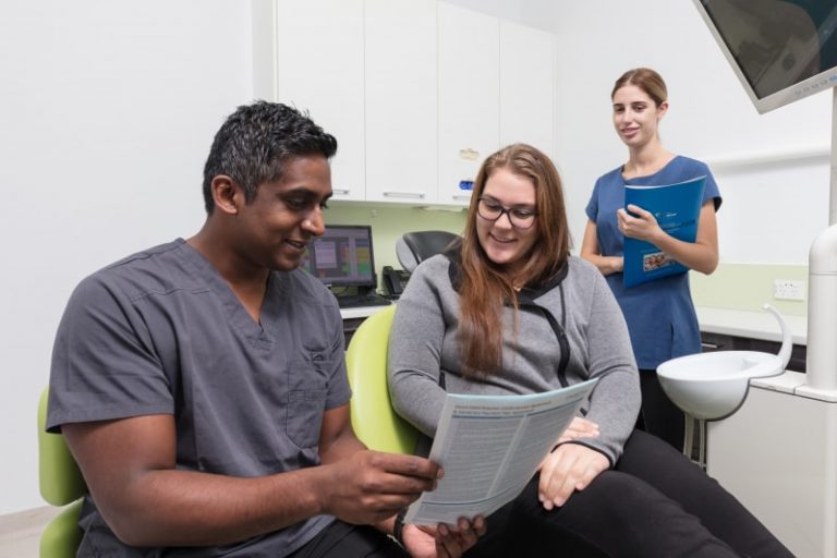 Dr Arun Thungavel and a dental nurse talking to a customer